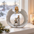 Änglafigur med julkrubba i fönstret