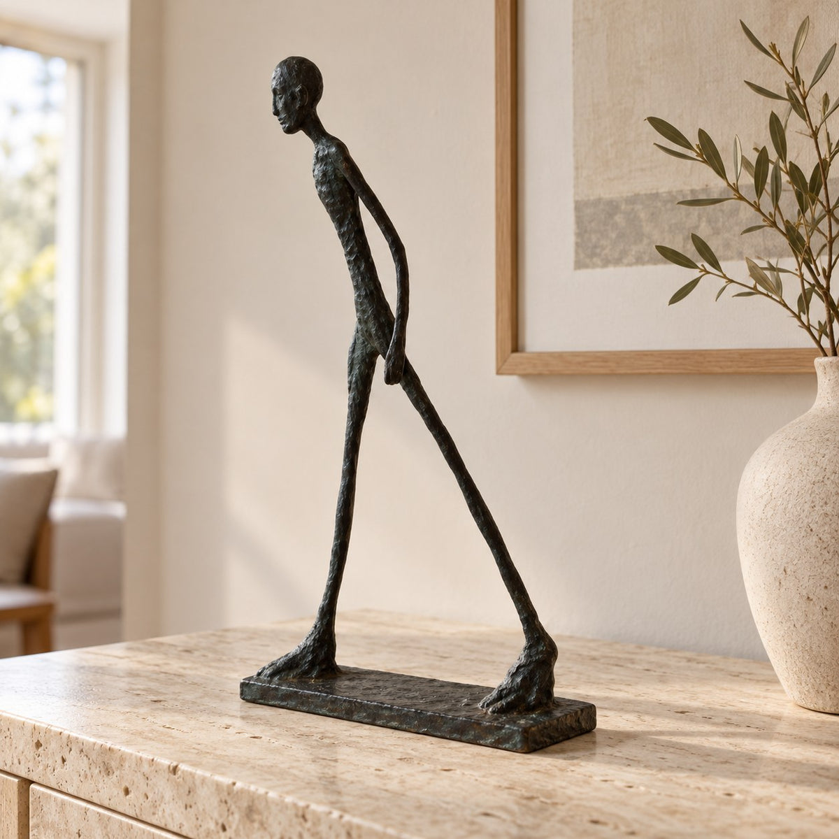 Gående figurskulptur i bronslook i närbild