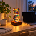 LED-björnlampa tänd på skrivbordet bredvid laptop i hemmakontoret